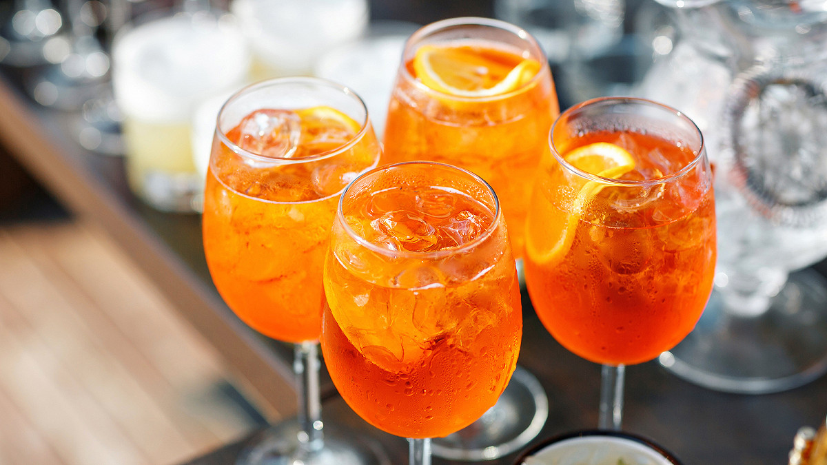 Aperol Spritz servi dans un verre ballon avec glaçons et rondelle d'orange